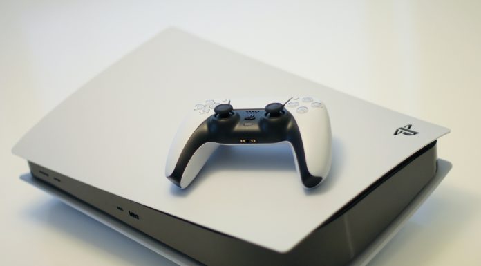 Console Playstation 5 blanche avec une manette posée dessus